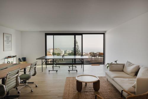 a living room with a couch and a table at Outsite Ericeira Praia do Sul - Work, Connect, Explore in Ericeira