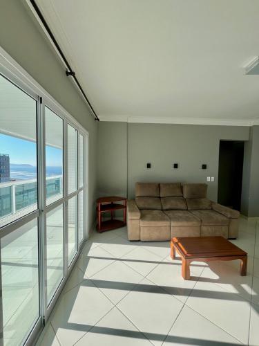 Cobertura Vista Mar com Piscina Privativa - PG في برايا جراندي: غرفة معيشة بها أريكة وطاولة