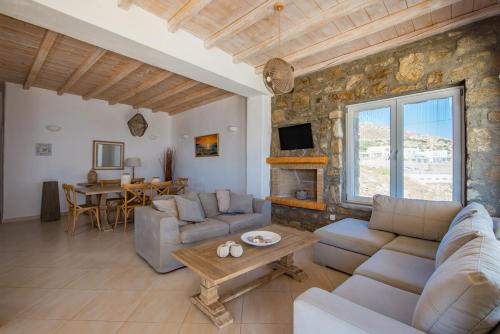 a living room with couches and a stone wall at Natural Stone Villa II in Mýkonos City