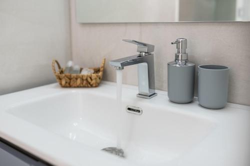 a bathroom sink with a faucet and two cups at Rock'n'Trullo 4 bedroom privatepool by TripOstuni in Ostuni