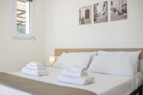 a white bed with towels on it with a window at Rock'n'Trullo 4 bedroom privatepool by TripOstuni in Ostuni
