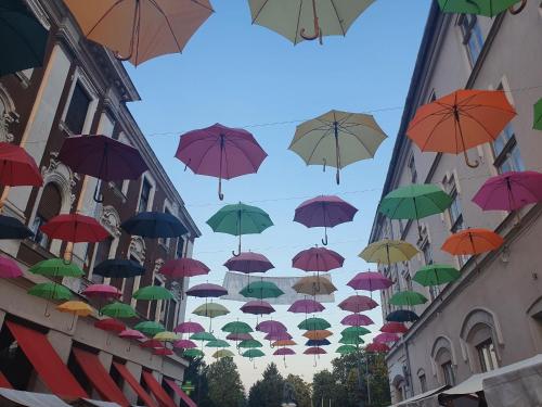 a bunch of umbrellas in the air above a street at Marusius Apartmanház in Makó