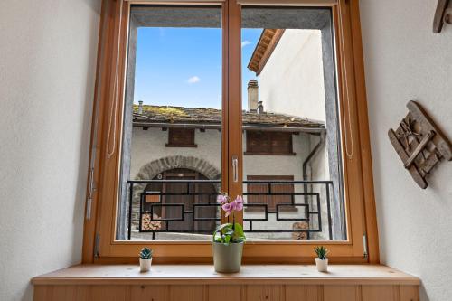 a window with a view of a building at Grand-St-Bernard, Liddes - 4 pers - cosy & rénové in Liddes