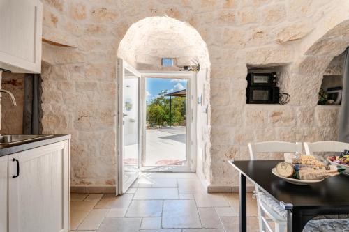a kitchen with an archway leading to a door at Rock'n'Trullo 4 bedroom privatepool by TripOstuni in Ostuni