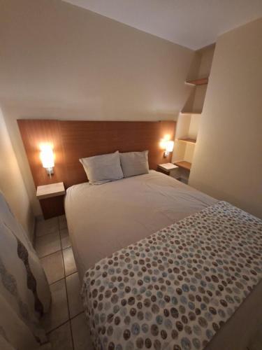a bedroom with a large bed and two lamps at Cottage Le Vau 3, RDC calme, lave linge, piscine in Chaveignes