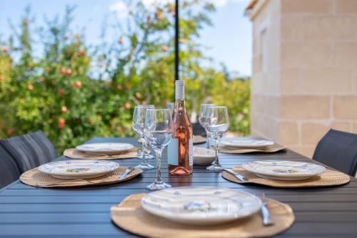 a table with plates and glasses and a bottle of wine at Rock'n'Trullo 4 bedroom privatepool by TripOstuni in Ostuni