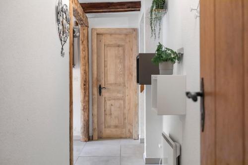 a hallway with a wooden door in a room at Grand-St-Bernard, Liddes - 4 pers - cosy & rénové in Liddes