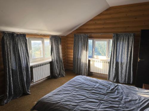 アルマトイにあるMountain house on the Kamensky Plateauのベッドと2つの窓がある寝室