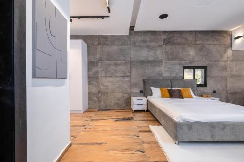 a bedroom with a bed and a stone wall at Hotel 46 in Haifa