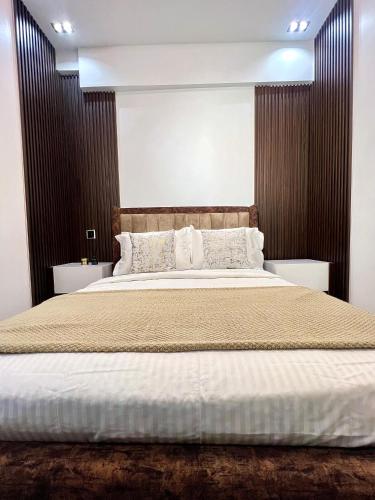 a bedroom with a large bed with a wooden headboard at 6a Thompson Avenue in Lagos