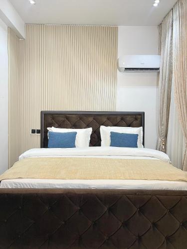a bedroom with a large bed with blue pillows at 6a Thompson Avenue in Lagos