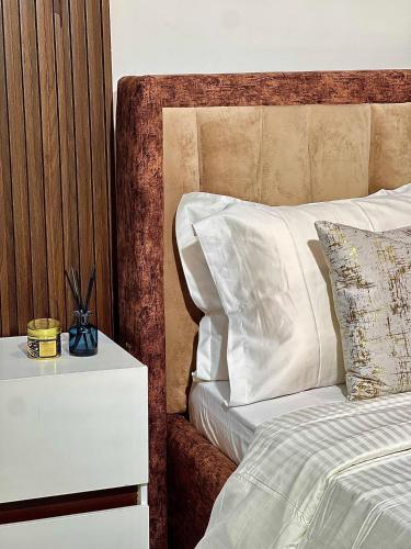 a bed with a night stand next to a white bed at 6a Thompson Avenue in Lagos