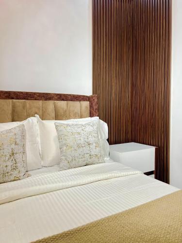 a bed with white sheets and pillows in a bedroom at 6a Thompson Avenue in Lagos