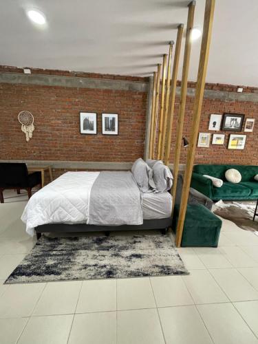 a bedroom with a bed and a brick wall at Loft cerca de todo con cochera in León