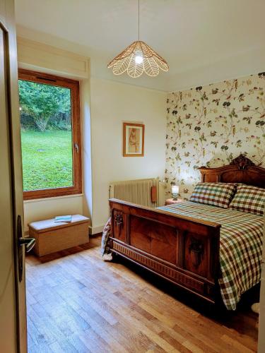 a bedroom with a large bed and a window at La Maison de Marie in Les Rouges-Eaux