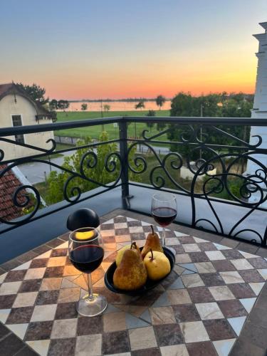 ein Tisch mit zwei Gläsern Wein auf einem Schachbrett in der Unterkunft White Palace in Palić