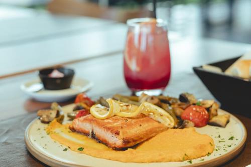 a plate of food with meat and vegetables and a drink at La Urumpta Hotel, AKEN MIND in Río Cuarto