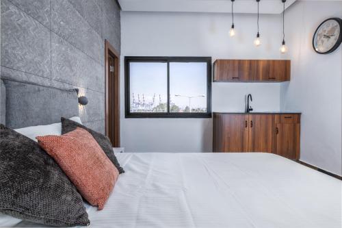 a bedroom with a large white bed and a window at Hotel 46 in Haifa