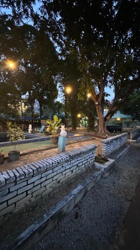 a brick wall with a statue in a park at night at Paradise Langkawi in Pulau Tepur