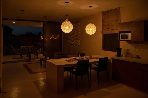a kitchen with a table and chairs and lights at Disfruta en La Casa de Lola / Enjoy at Lolas house in Progreso
