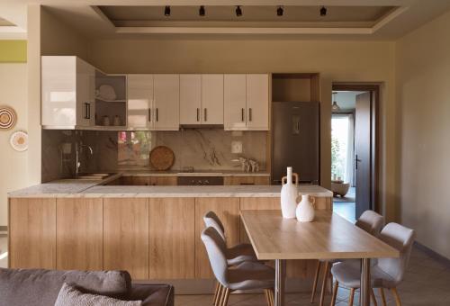 a kitchen with a wooden table and a dining room at Ilision Aqua - Exclusive Private Pool Suites in Argasi