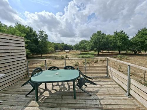 a table and two chairs on a wooden deck at Cottage Rembrandt in Chaveignes