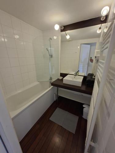a bathroom with a sink and a bath tub at Cottage Rembrandt in Chaveignes