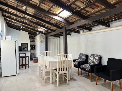 a dining room with a white table and chairs at Pousada Suíte Suzena in Penha