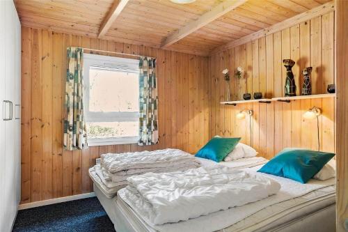 Un dormitorio con dos camas en una habitación con paredes de madera. en LN76137-Hjorring-Nordsovej-39, en Hjørring
