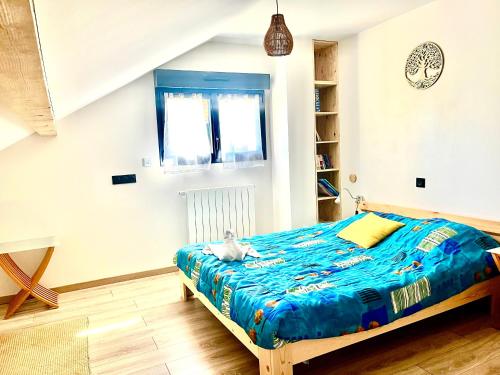 a bedroom with a bed with a blue comforter at Sub zéro in Saint-Jean-de-Tholome
