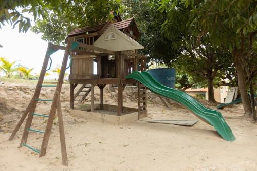 a playground with a slide and a play house at Pasargada Hotel in Crato