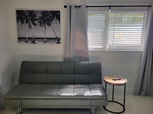 a couch in a room with a table and a window at Kevin #2 Studio in Fort Lauderdale