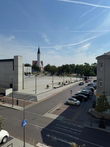 a parking lot with cars parked in a parking lot at City Centre Apartment with Cathedral View, Self Check-in in Šiauliai