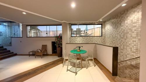 a room with a table and chairs and a brick wall at Luxo Frente Mar em 7 Qtos com Ar sendo 4 suites para até 18 pessoas, 2 Jacuzzi Aquecidas, piscina, brinquedoteca, 5min de Castelhanos in Anchieta