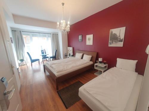 a bedroom with two beds and a red wall at Brixton Rooms & Apartments Budapest in Budapest