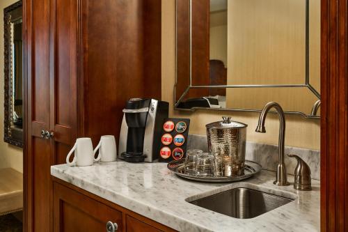 a kitchen counter with a sink and a coffee maker at Woolley's Classic Suites in Aurora