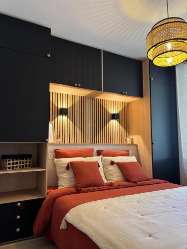 a bedroom with a large bed with red and white pillows at Le Ruby in Amboise