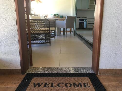 a door leading to a kitchen with a welcome mat at Ykutiba Imbassaí - Apartamento 2 Quartos - H104 in Imbassai