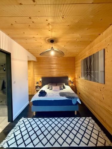 a bedroom with a bed and a wooden wall at Le Fournil du Couvent in Les Rousses
