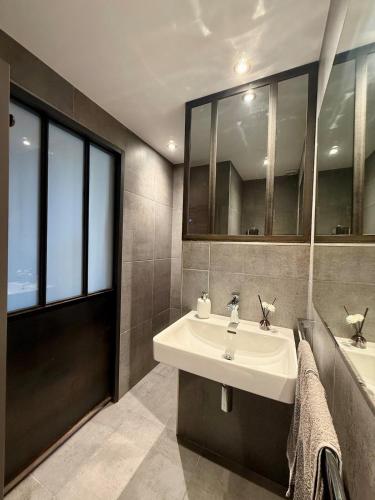 a bathroom with a sink and a mirror at Le Fournil du Couvent in Les Rousses