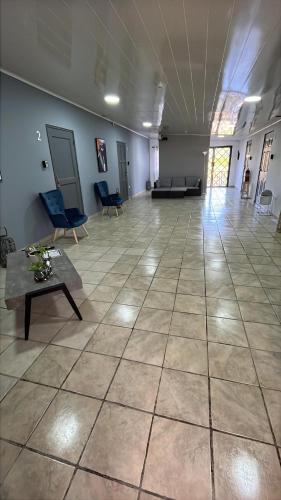 a large room with a large tile floor with chairs and a table at MOMA Guest House en Alto Boquete in Alto Boquete