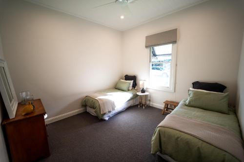 a bedroom with two beds and a window at Ravenscroft Cottage in Eccleston
