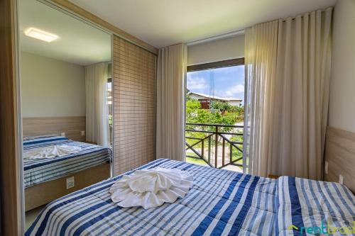 a bedroom with two beds and a large window at Ykutiba Imbassaí - Apartamento Superior - I104 in Imbassai