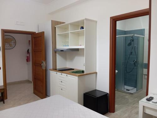 a bedroom with a shower and white cabinets and a bed at Regency House Accoglienza in Portici