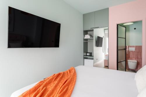 1 dormitorio con TV de pantalla plana en la pared en Charm Beach Retreat, en Alicante