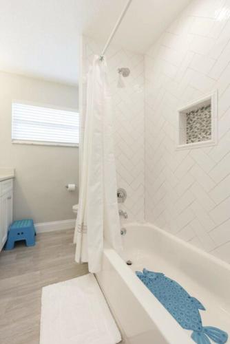 a white bathroom with a tub and a shower at The Seaside Retreat, FREE heated pool in Apollo Beach