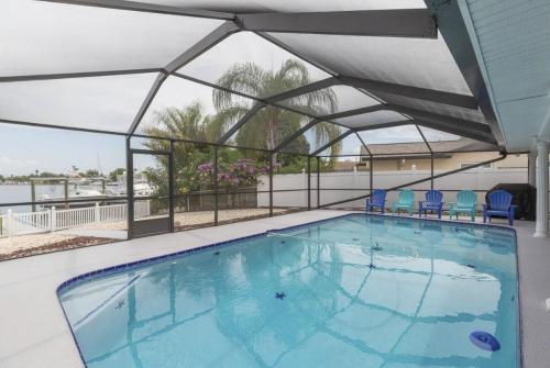 a large swimming pool with blue chairs in a building at The Seaside Retreat, FREE heated pool in Apollo Beach
