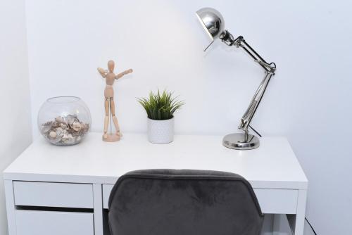 a white desk with a black chair and a lamp at Luxury 2-Bed Apt - Heart of Bham Free Parking in Birmingham