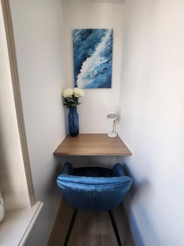 a blue chair sitting under a table in a room at Suite et duplex avec terrasse en hyper centre in Charleville-Mézières
