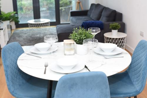 a white table with blue chairs in a living room at Luxury 2-Bed Apt - Heart of Bham Free Parking in Birmingham